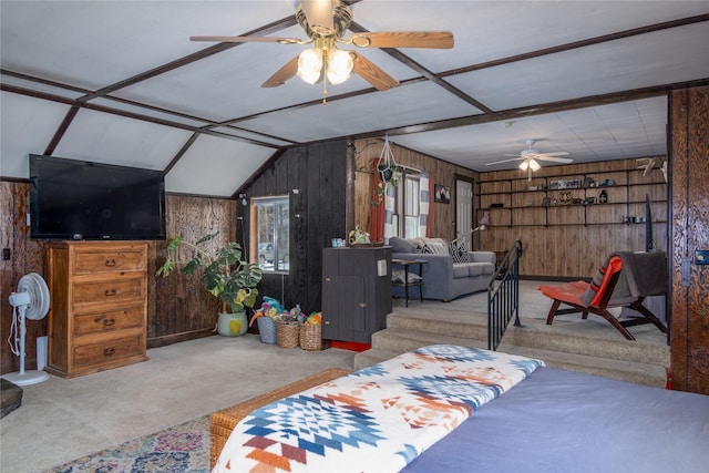 carpeted bedroom featuring lofted ceiling and wooden walls
