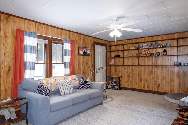 living room featuring light colored carpet, ceiling fan, and wood walls