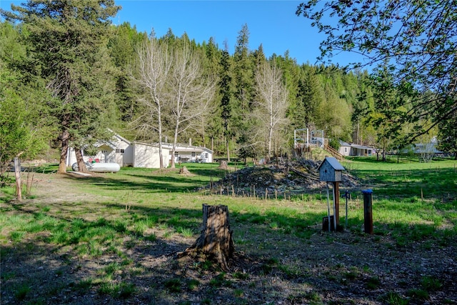 surrounding community with a forest view and a lawn