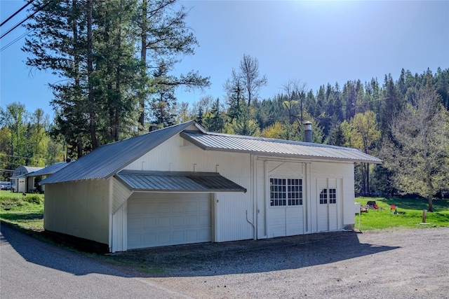 detached garage featuring a forest view