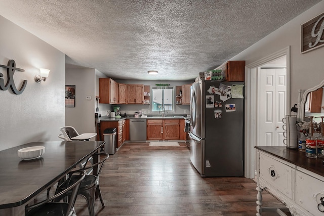 kitchen featuring a textured ceiling, dark hardwood / wood-style floors, sink, and stainless steel appliances