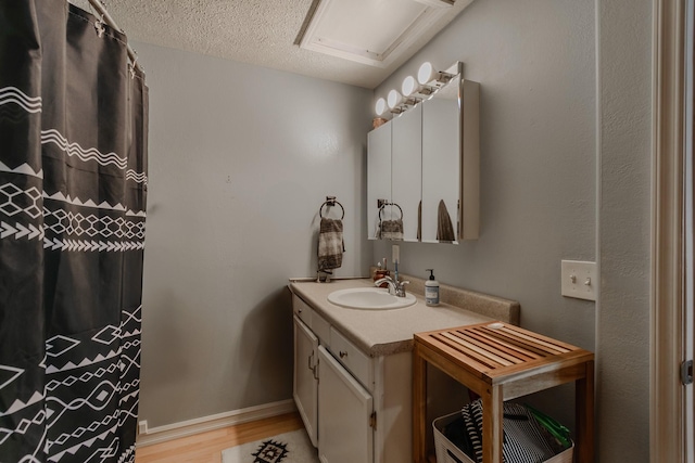 bathroom featuring vanity, wood-type flooring, and a textured ceiling