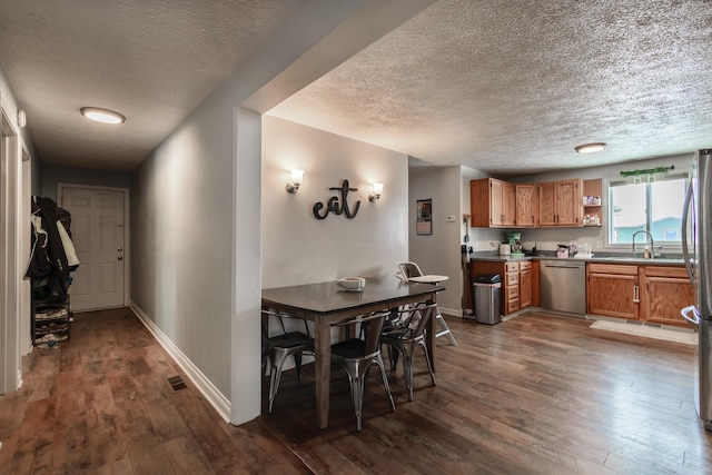 dining area with a textured ceiling, dark hardwood / wood-style floors, and sink