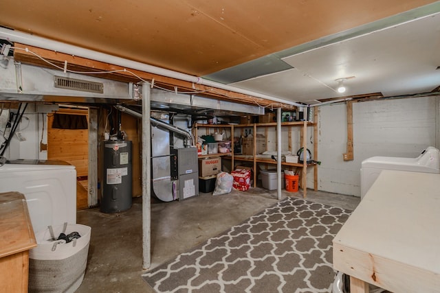 basement with heating unit, electric water heater, and washing machine and clothes dryer