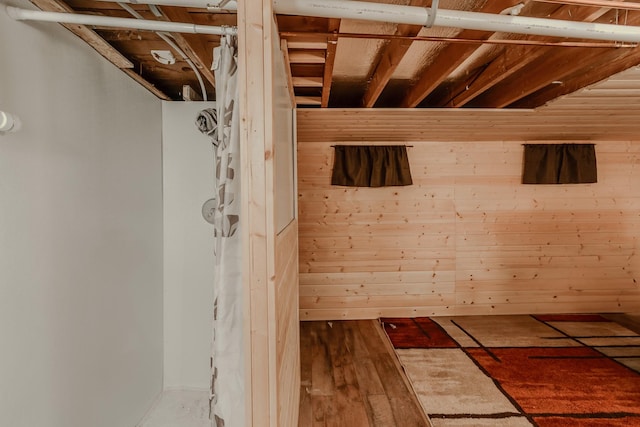 bathroom featuring hardwood / wood-style flooring and wooden walls