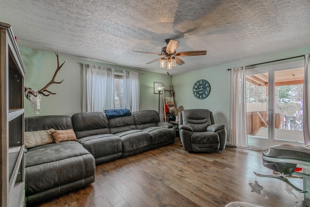 living room with a wealth of natural light, ceiling fan, wood-type flooring, and a textured ceiling