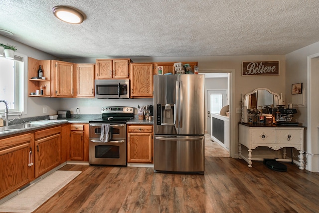 kitchen featuring a textured ceiling, stainless steel appliances, dark hardwood / wood-style floors, and sink