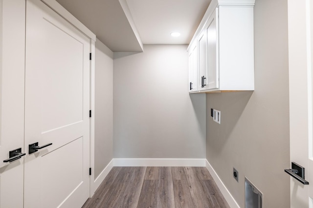 laundry area with washer hookup, hookup for an electric dryer, cabinets, and light hardwood / wood-style flooring