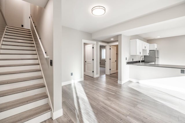 staircase featuring sink and hardwood / wood-style flooring