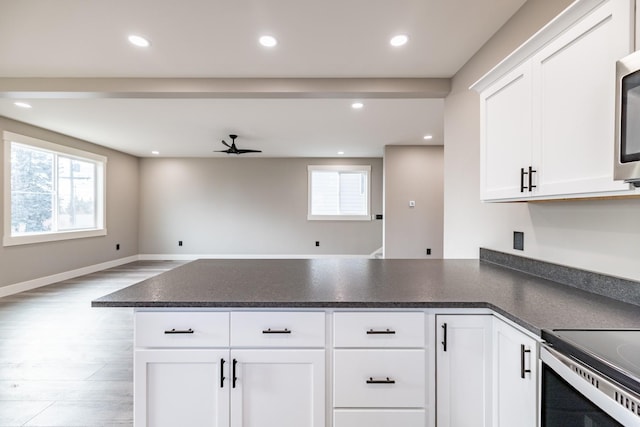 kitchen with kitchen peninsula, ceiling fan, white cabinets, and light hardwood / wood-style floors