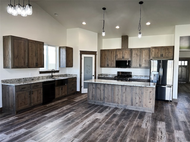 kitchen with hanging light fixtures, a center island, black appliances, and dark brown cabinets