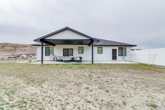 back of property featuring an outdoor living space and a patio area