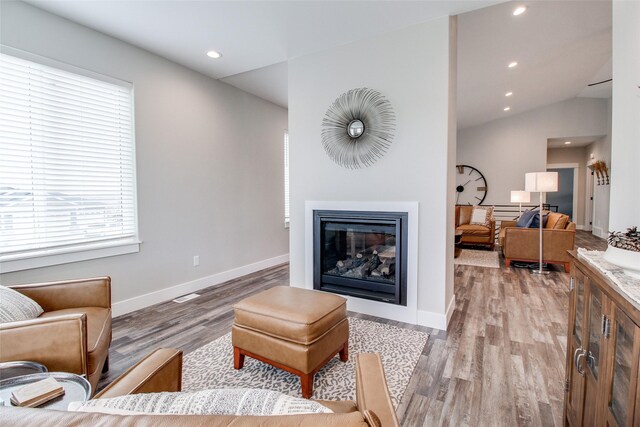 living room with light hardwood / wood-style flooring and lofted ceiling