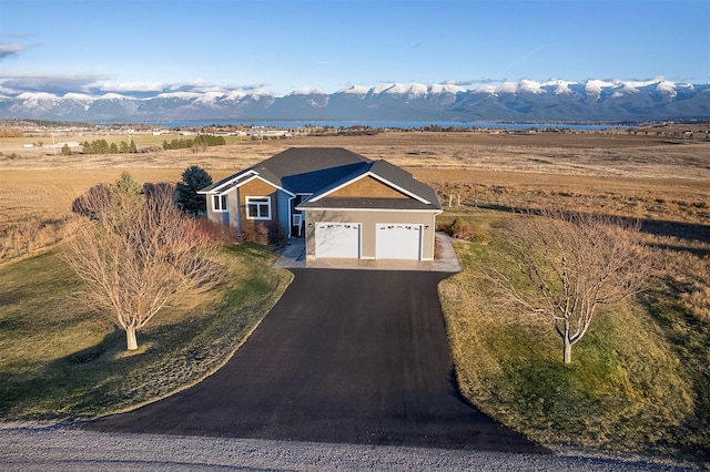 view of front of property with a mountain view, a rural view, and a garage