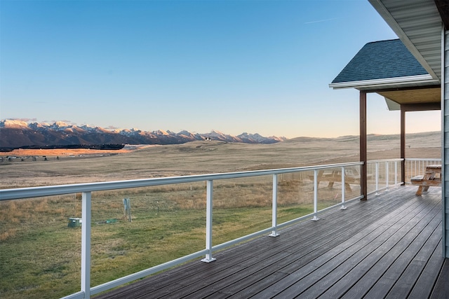 deck at dusk featuring a rural view