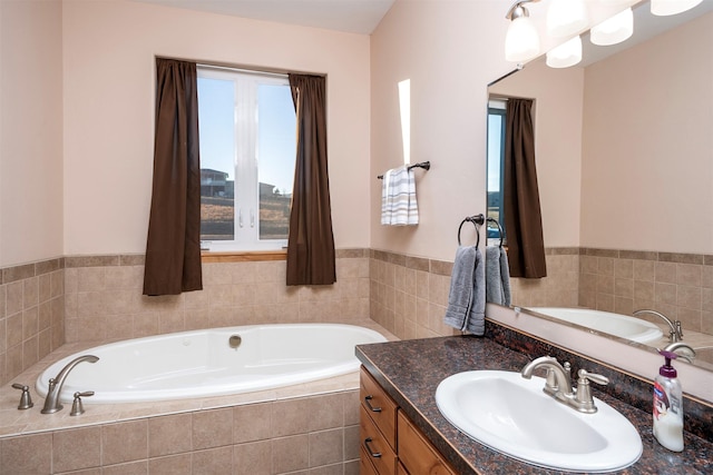 bathroom featuring vanity and tiled tub