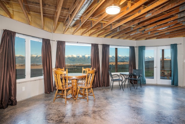 dining room featuring french doors, a water view, and a high ceiling