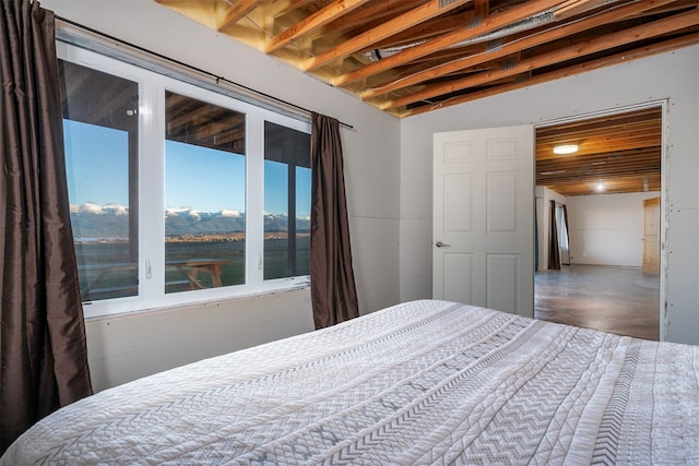 bedroom featuring concrete flooring and vaulted ceiling