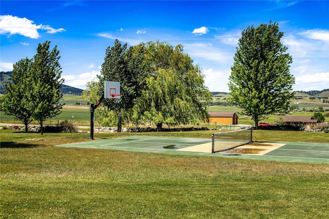 view of sport court featuring a lawn