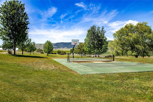 view of basketball court with a lawn and a mountain view