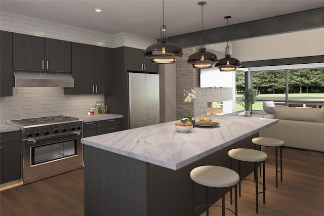 kitchen featuring dark hardwood / wood-style floors, pendant lighting, a breakfast bar area, decorative backsplash, and appliances with stainless steel finishes