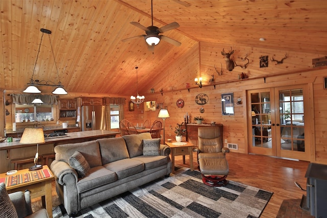 living room featuring vaulted ceiling, dark hardwood / wood-style floors, french doors, ceiling fan with notable chandelier, and wooden ceiling