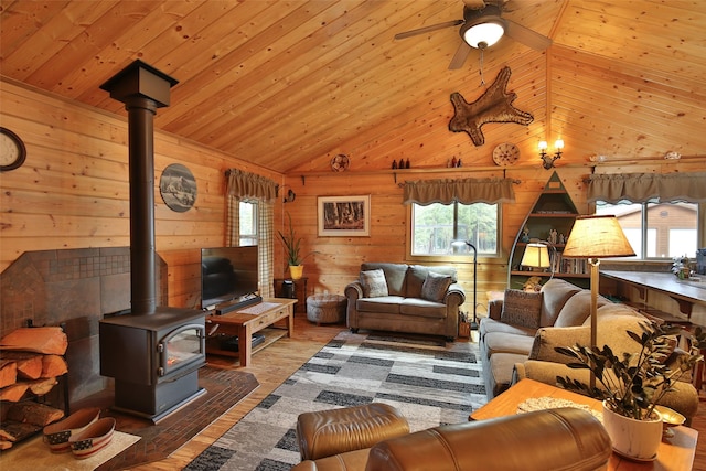 living room featuring ceiling fan, dark hardwood / wood-style floors, wooden walls, wood ceiling, and a wood stove