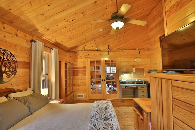 bedroom featuring lofted ceiling, wooden walls, light hardwood / wood-style flooring, french doors, and wooden ceiling