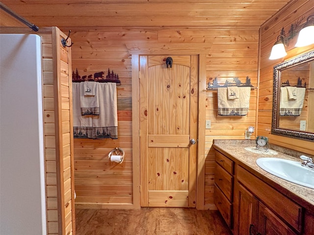 bathroom featuring vanity, wooden walls, and wooden ceiling