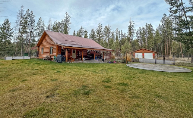 rear view of property with a garage, a lawn, and an outdoor structure