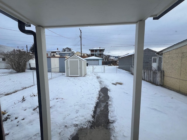 yard covered in snow with a shed