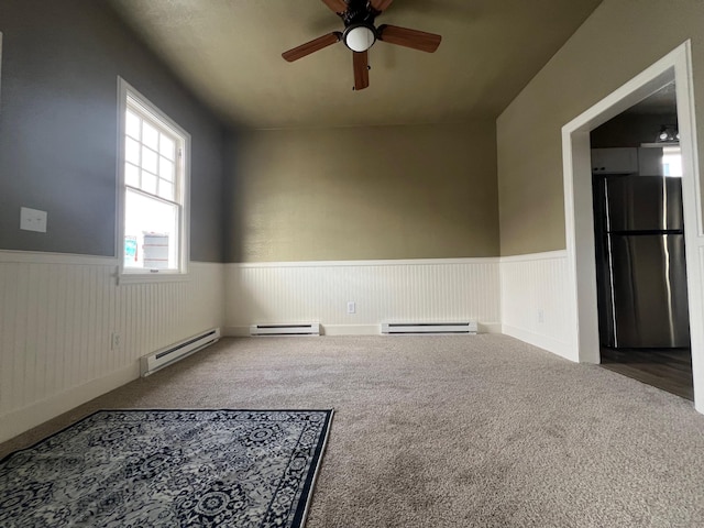 carpeted empty room featuring a baseboard radiator and ceiling fan