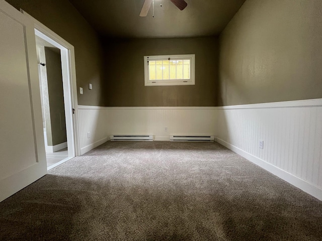 empty room featuring baseboard heating, ceiling fan, and carpet