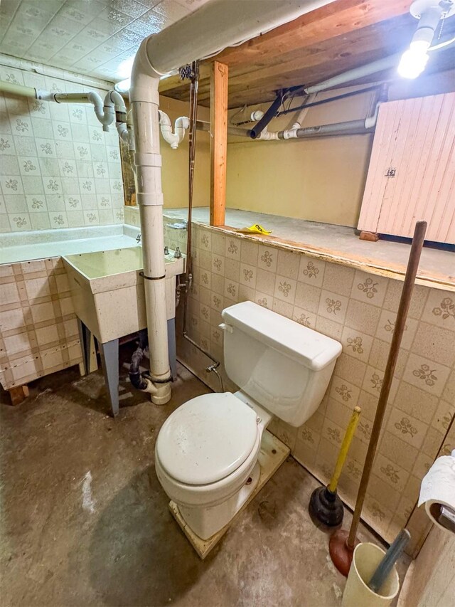 bathroom with concrete flooring and toilet