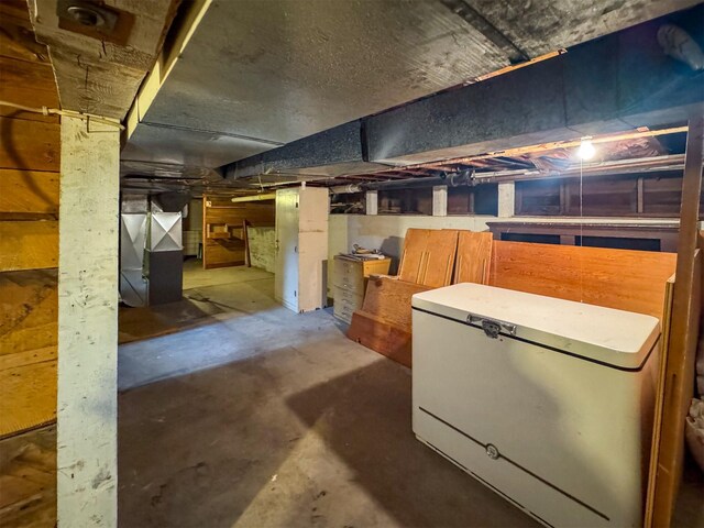 basement with heating unit and fridge