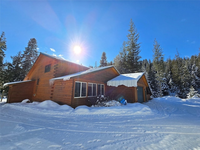 view of snow covered exterior featuring a garage