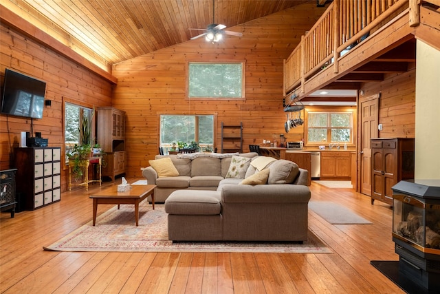 living room featuring light hardwood / wood-style flooring, high vaulted ceiling, and wooden walls