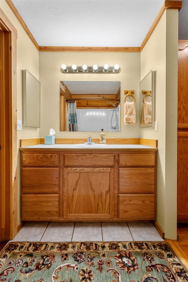 bathroom featuring crown molding, vanity, a shower with curtain, and tile patterned flooring