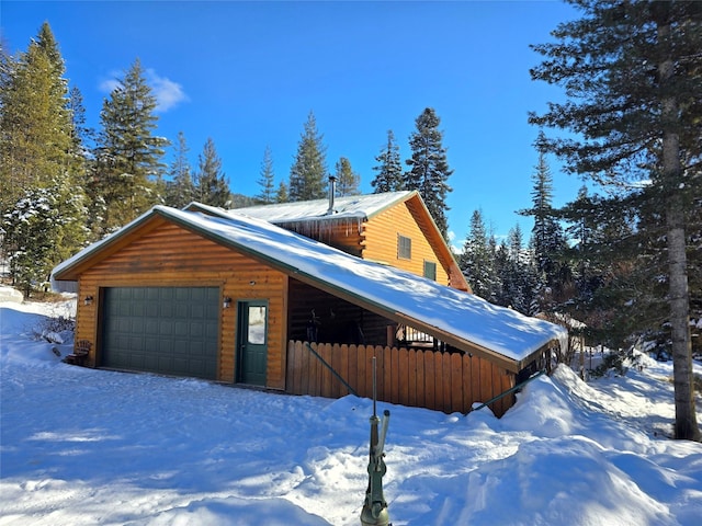 snow covered property featuring a garage