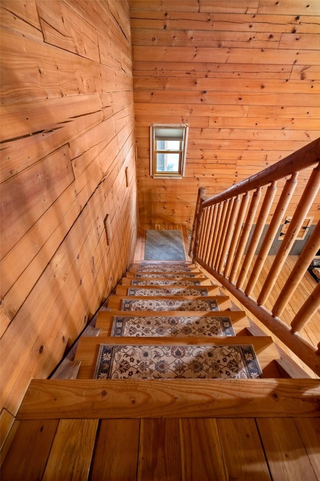 staircase featuring wooden walls