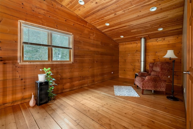 living area with wooden walls, vaulted ceiling, light hardwood / wood-style flooring, and wooden ceiling