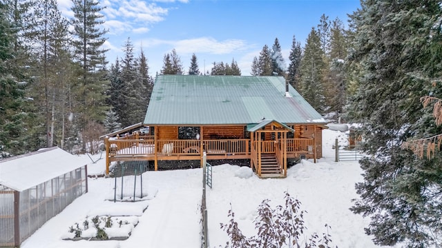 snow covered back of property featuring a deck