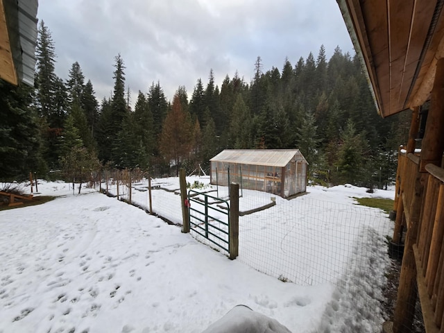 yard layered in snow featuring an outdoor structure