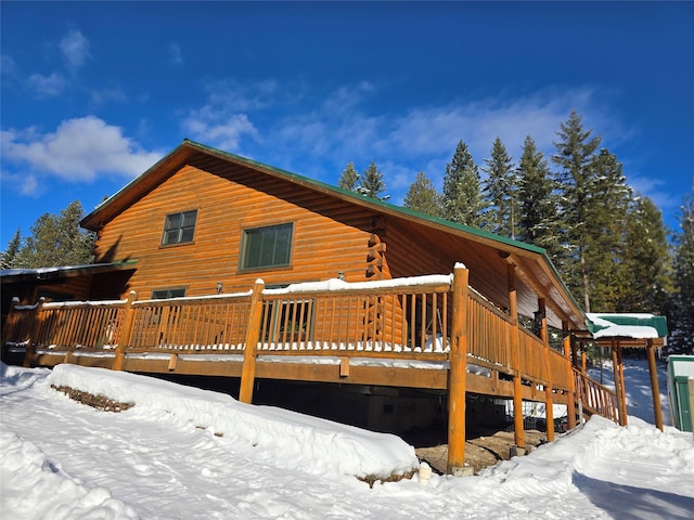 snow covered house with a wooden deck