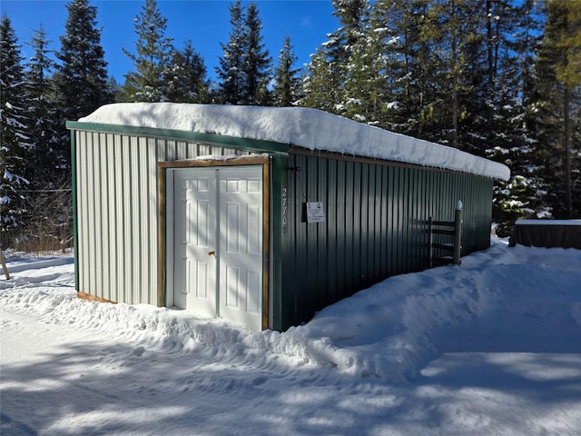 snow covered structure with a garage