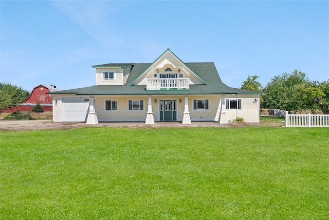 view of front of house featuring covered porch, a garage, a balcony, and a front lawn