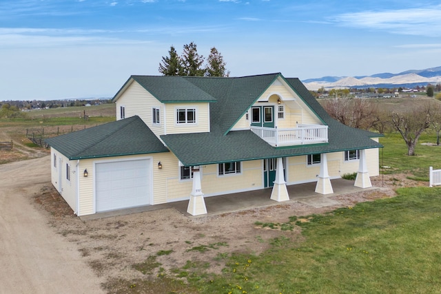 358 Hamilton Heights Rd, Corvallis, MT 59828 - view of front of property featuring a balcony, covered porch, roof with shingles, an attached garage, and a mountain view