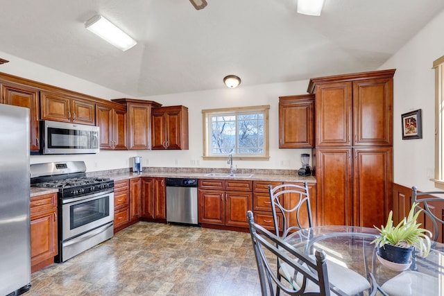 358 Hamilton Heights Rd, Corvallis, MT 59828 - kitchen featuring brown cabinetry, light stone countertops, a sink, stone finish flooring, and appliances with stainless steel finishes