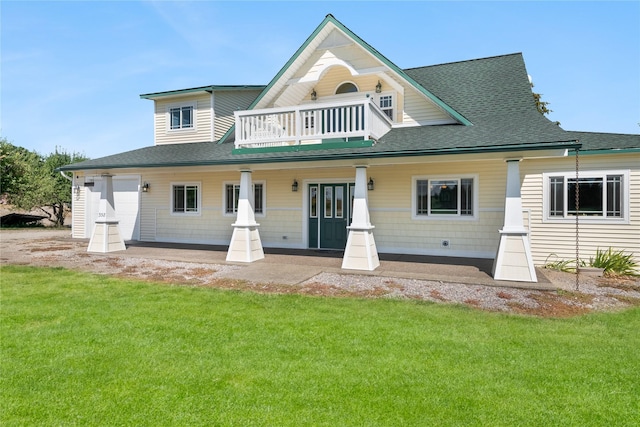 back of property with a lawn, a balcony, a porch, and a garage