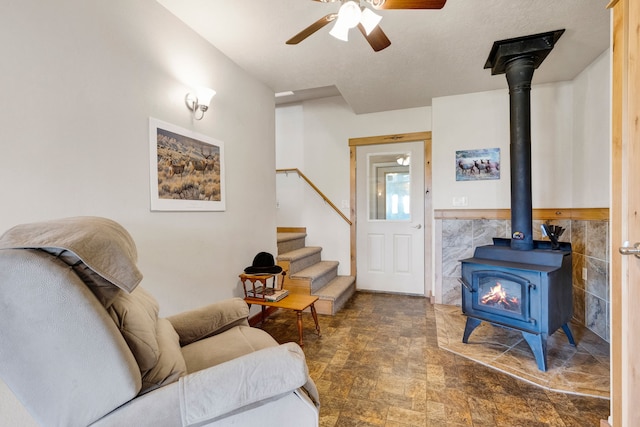 358 Hamilton Heights Rd, Corvallis, MT 59828 - living area with a ceiling fan, stairway, stone finish flooring, and a wood stove